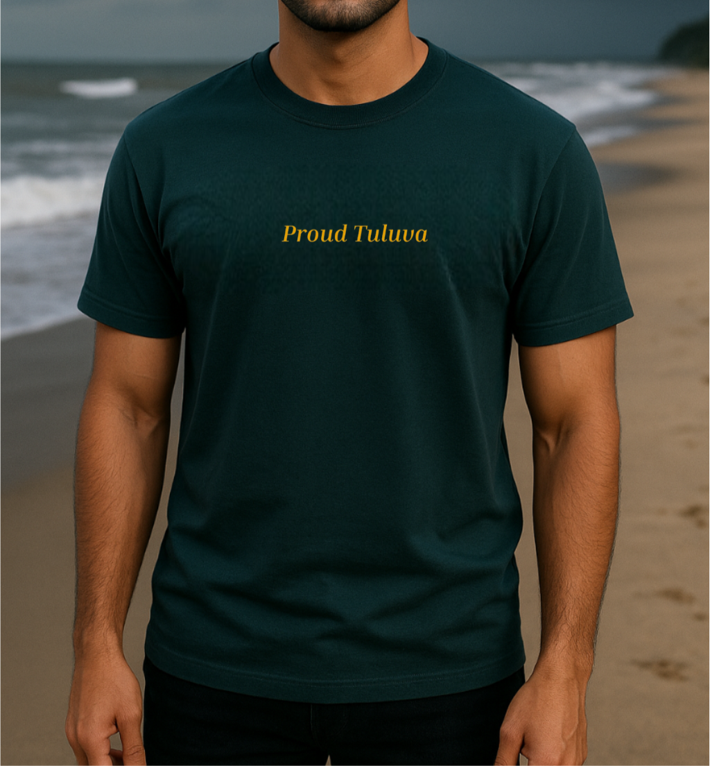 Person wearing a petrol blue t-shirt with 'Proud Tuluva' text on a beach.